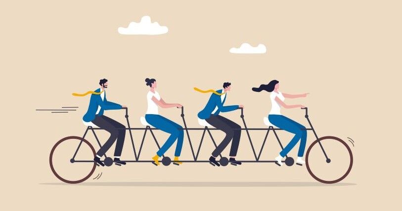 4 figures of workers dressed in jackets and pants ride a single long bicycle. Two riders' yellow ties fly behind them in the wind