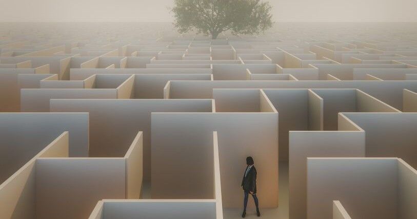 A small female figure stands in a maze with white walls. Far in the distant background, a large tree looms over the maze.