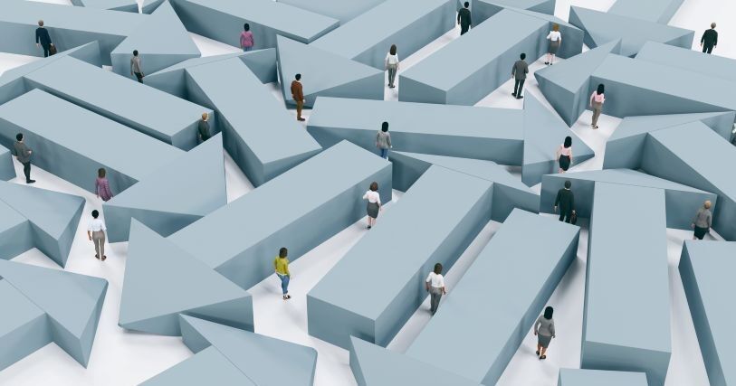 Tiny people in professional clothing wander among a forest of large gray arrows